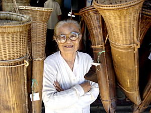 alte Korbhändlerin auf einem Markt in Laos